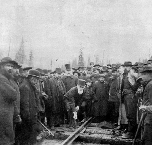 A crowd of people surround a man leaning forward.