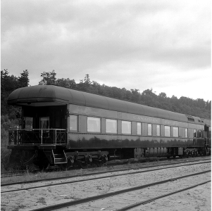 A black and white photo of the outside of a train.