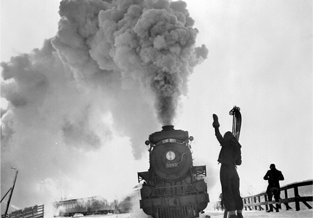 A black and white frontal view of a moving train.