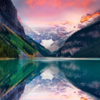 A lake with a reflection of its surrounding landscape and mountains.