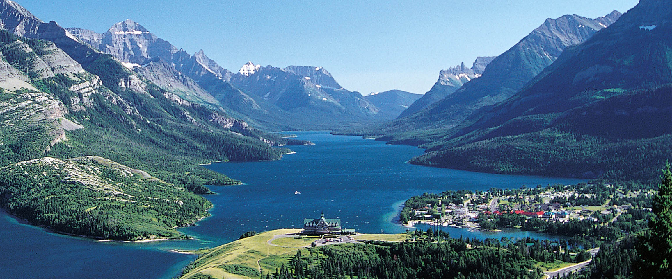 An aerial view of a body of water in between mountains.